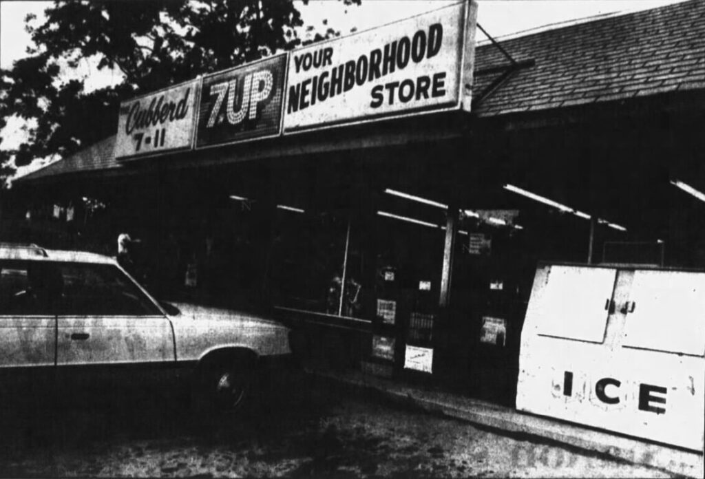 A black and white photograph of a convenience store. A sign reads "Cubberd 7-11, 7UP, Your Neighborhood Store." An ice machine and an  80s model car are outside. The store where the murder of Missy Macon took place.